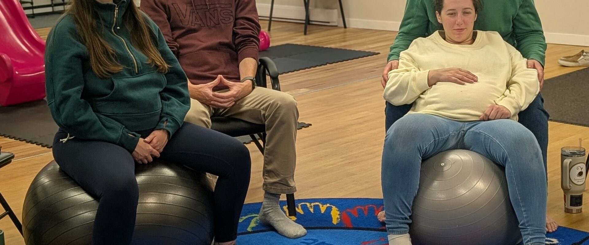 Group of expectant parents and caregivers gathered in a circle at PACT